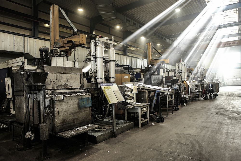 A machining hall with a press line running under shafts of daylight.