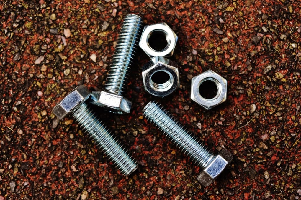 A dense bed of machined metal fasteners recovered for reuse.